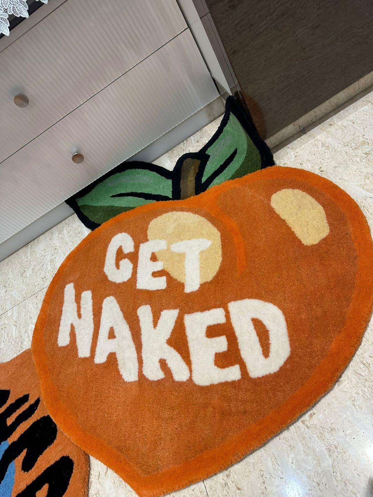 Get Naked peach-shaped tufted rug in orange with green leaf