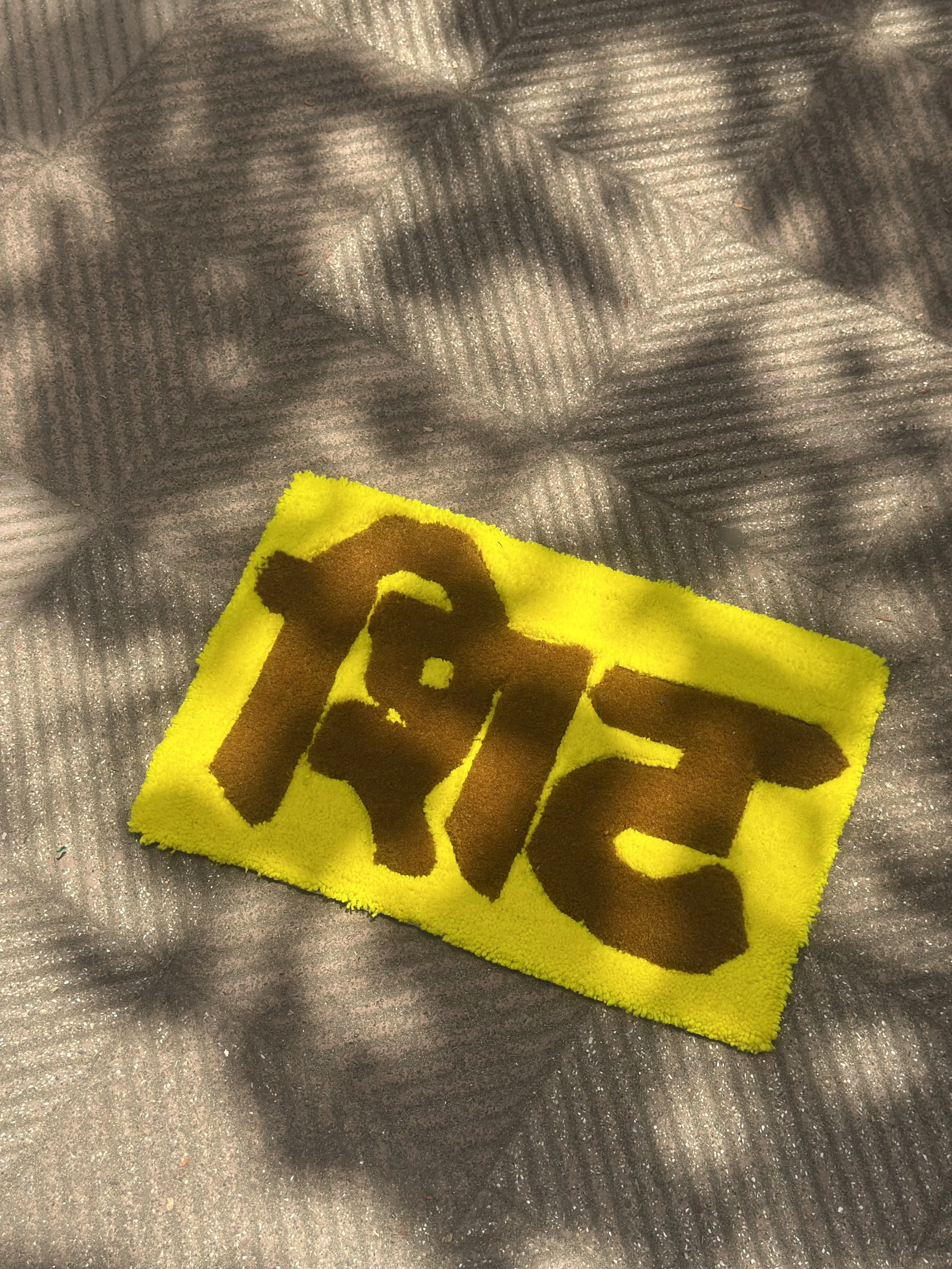 Yellow hand tufted ‘SHIT’ rug